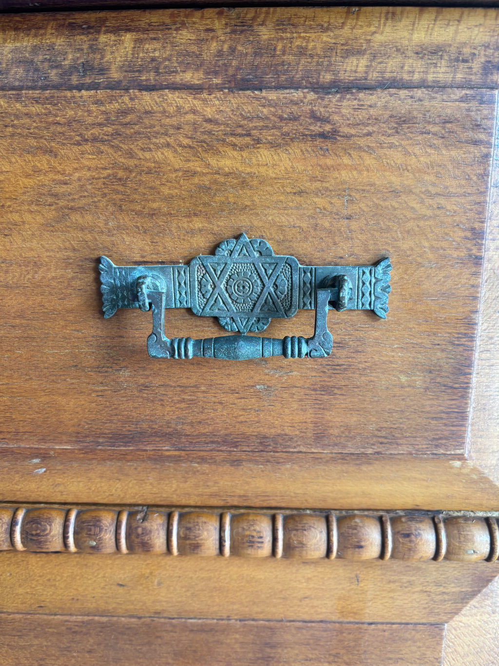 Decorative metal handle on a wooden surface