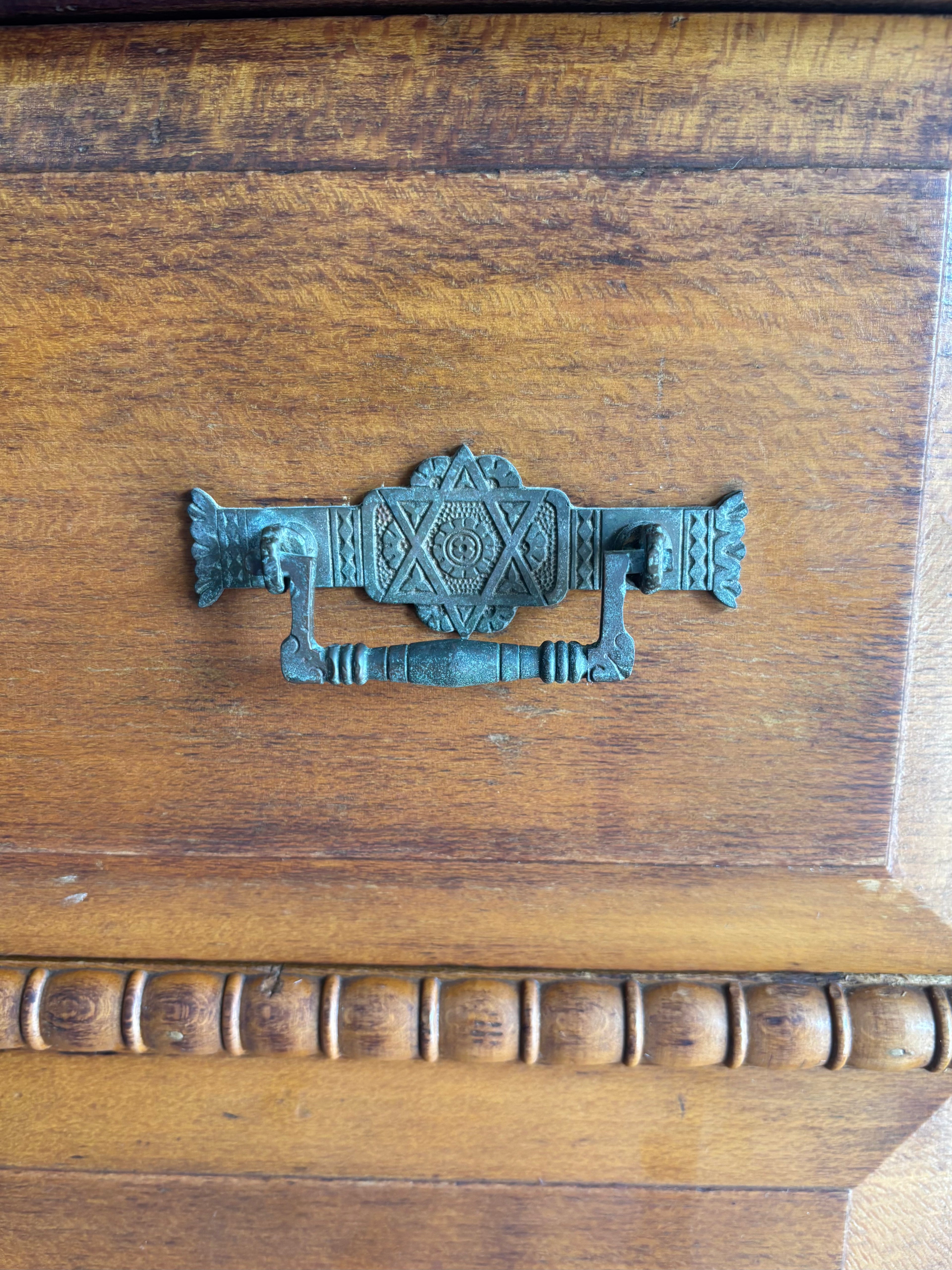Decorative metal handle on a wooden surface
