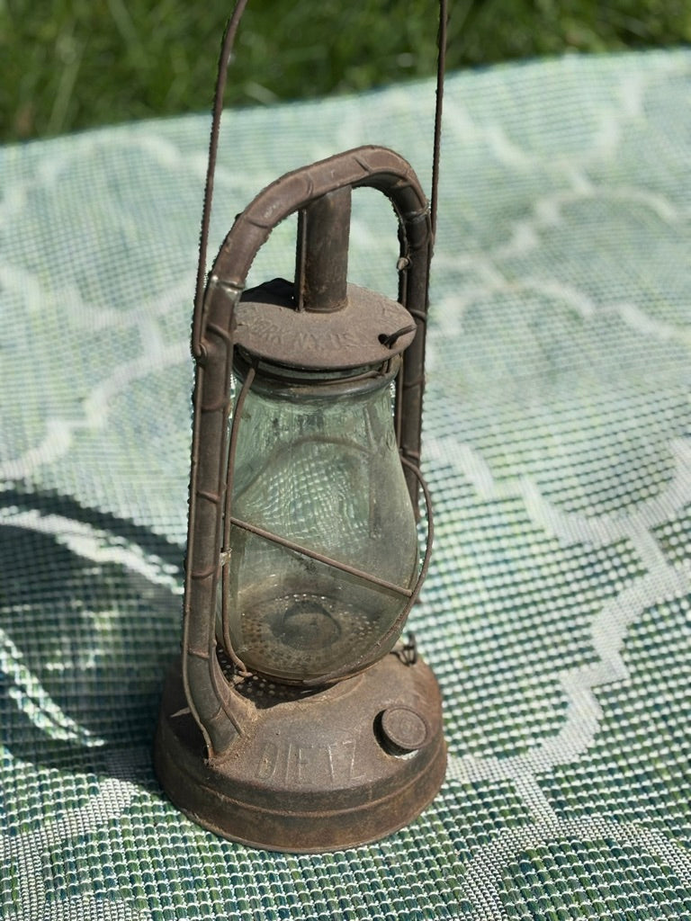 Vintage-style lantern on a textured green surface with grass in the background