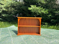 Wooden bookshelf on a green patterned surface with a natural background