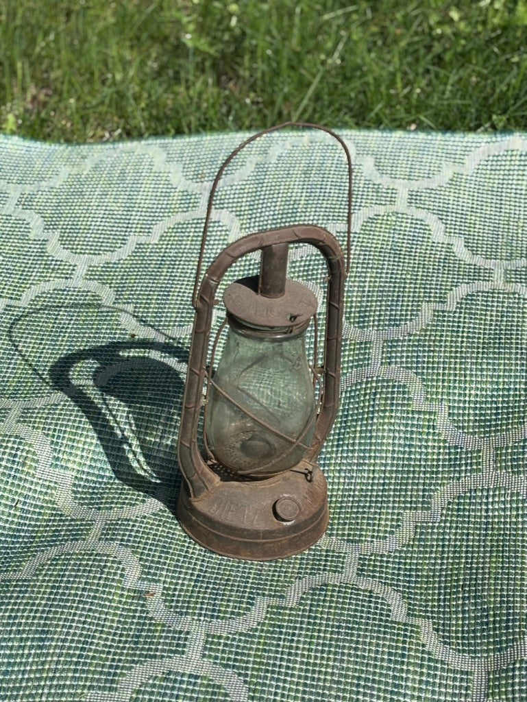 Vintage lantern on a green checkered cloth with grass in the background
