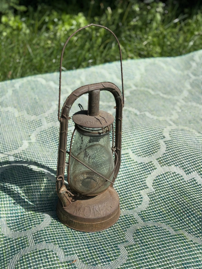 Vintage-style lantern on a green textured surface with grass in the background